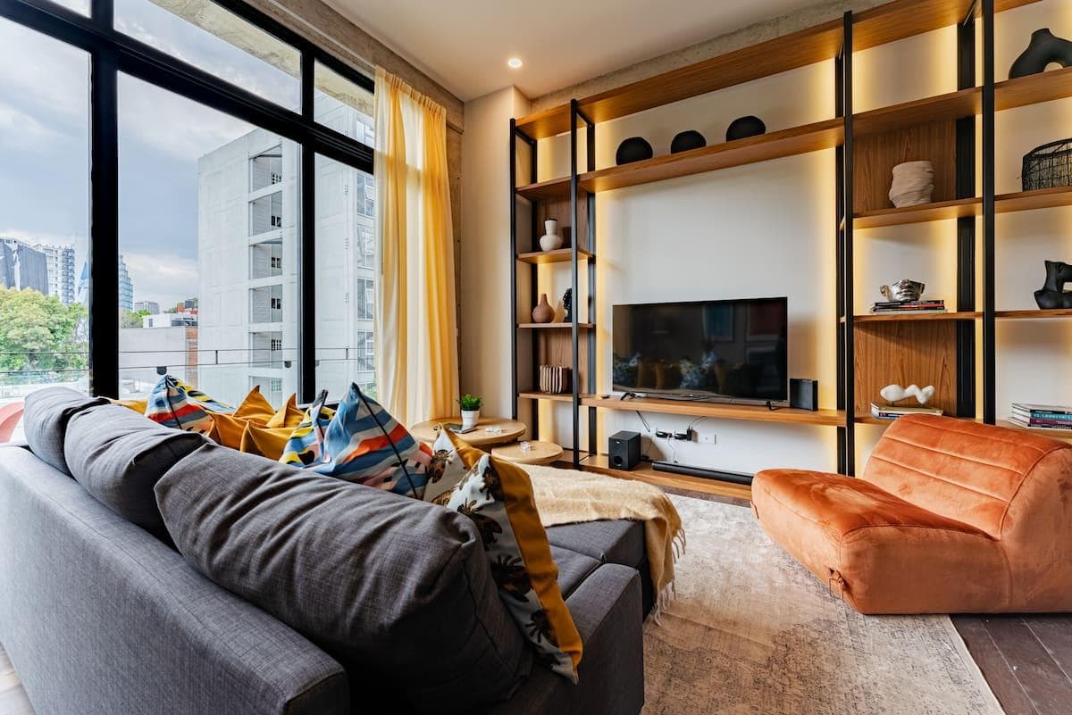 Contemporary living room with a sectional sofa, fireplace, and city view.