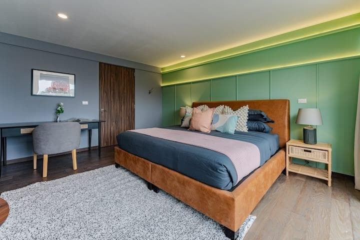 Home office area with a desk, chair, and a glimpse into a modern bedroom.