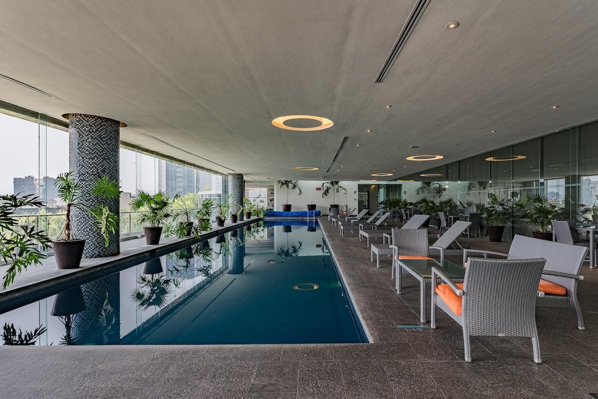 Indoor pool with comfortable lounge chairs and natural light.