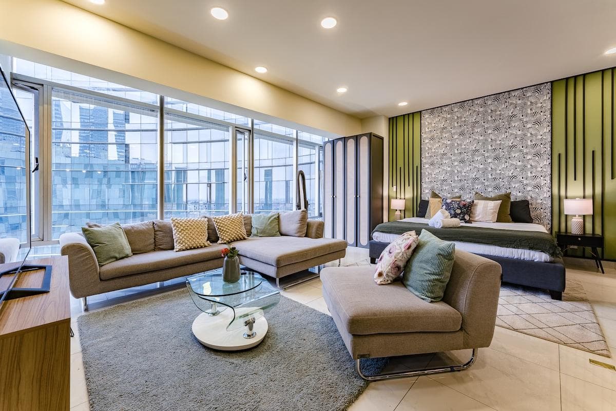 Spacious living room with floor-to-ceiling windows and city views.