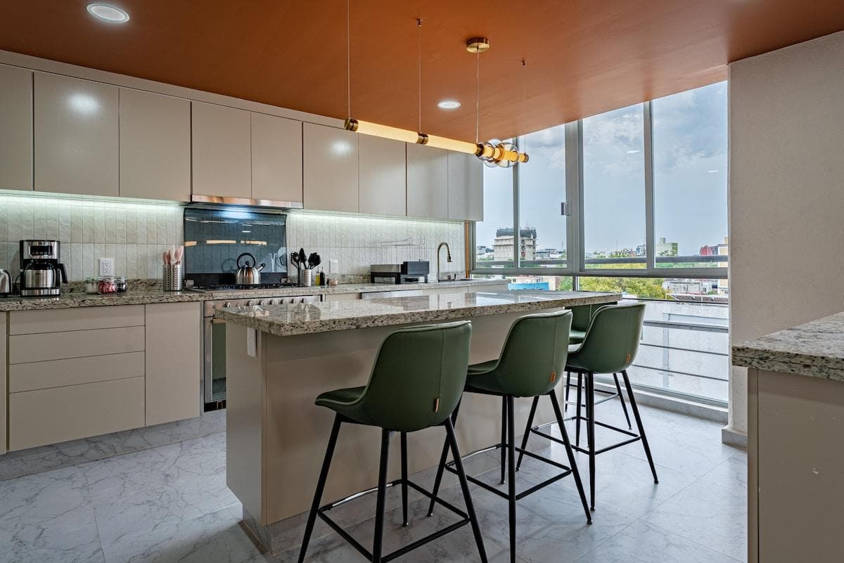 Fully equipped kitchen with island seating, and expansive city views.