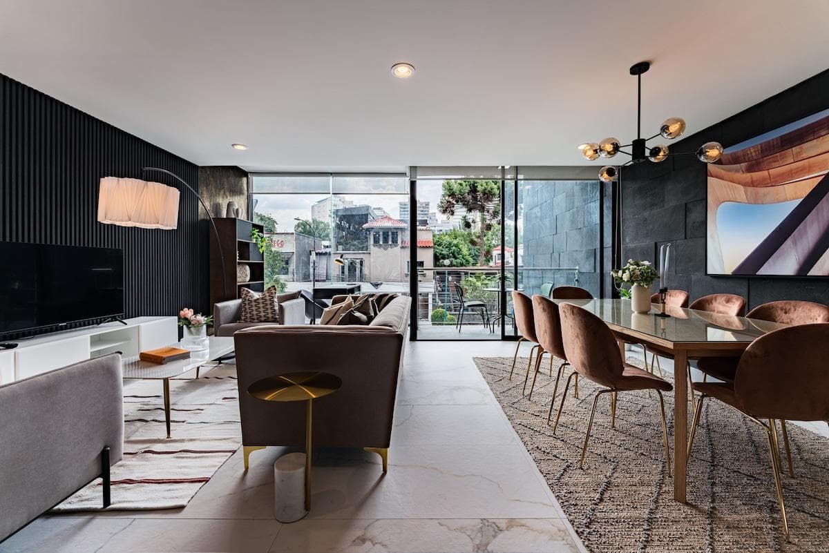 Elegant, sunlit dining and living space with floor-to-ceiling windows