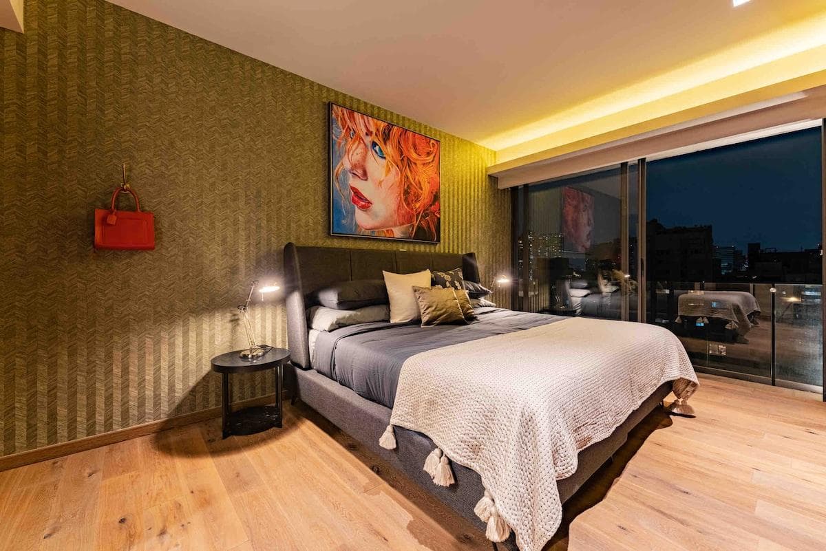 Master bedroom with plush bedding and a private balcony.