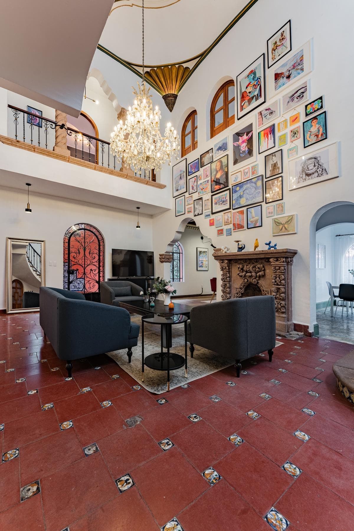 Living room with decorative fireplace, large chandelier and double height ceiling.