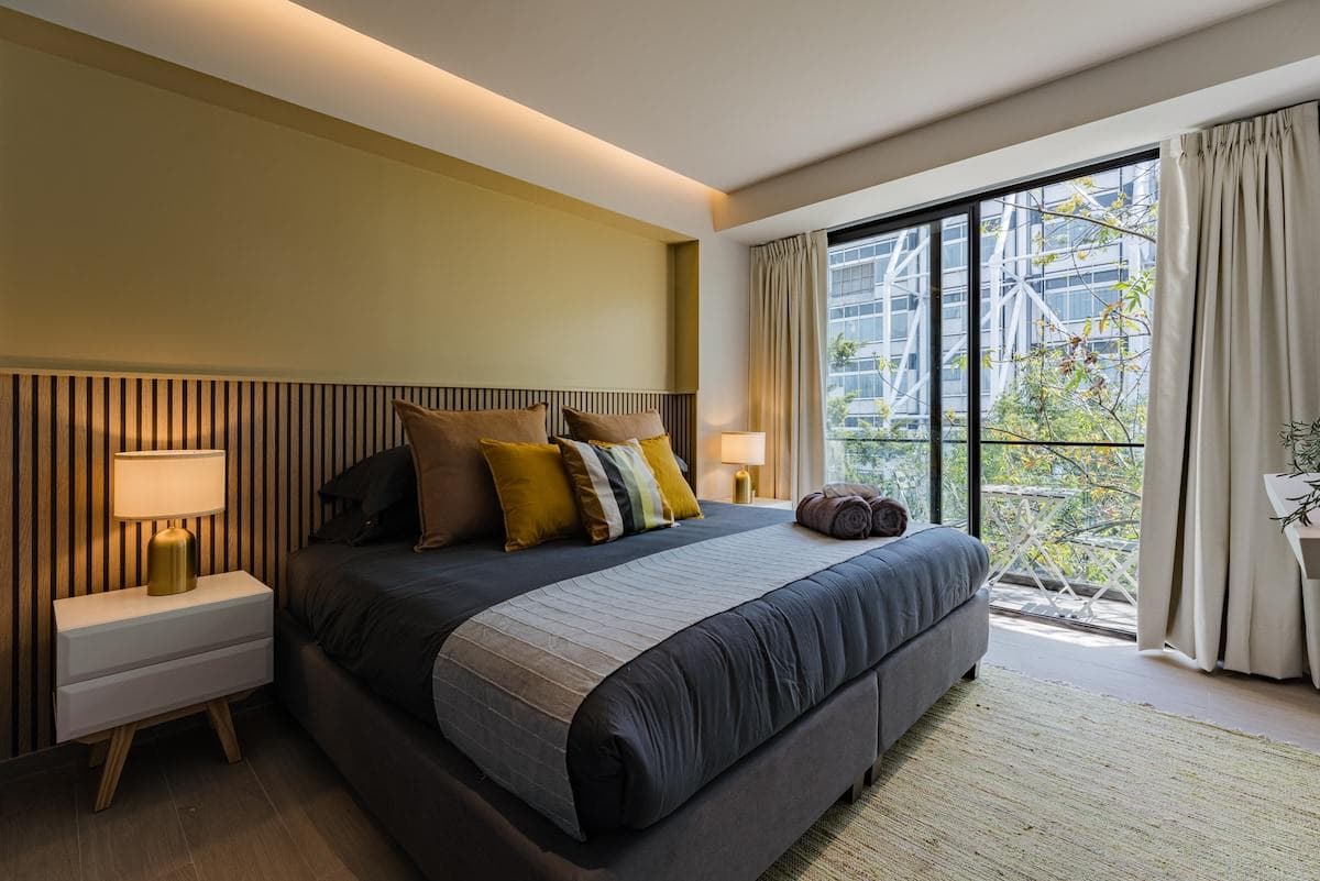 Comfortable king bed with soft linens and ample lighting