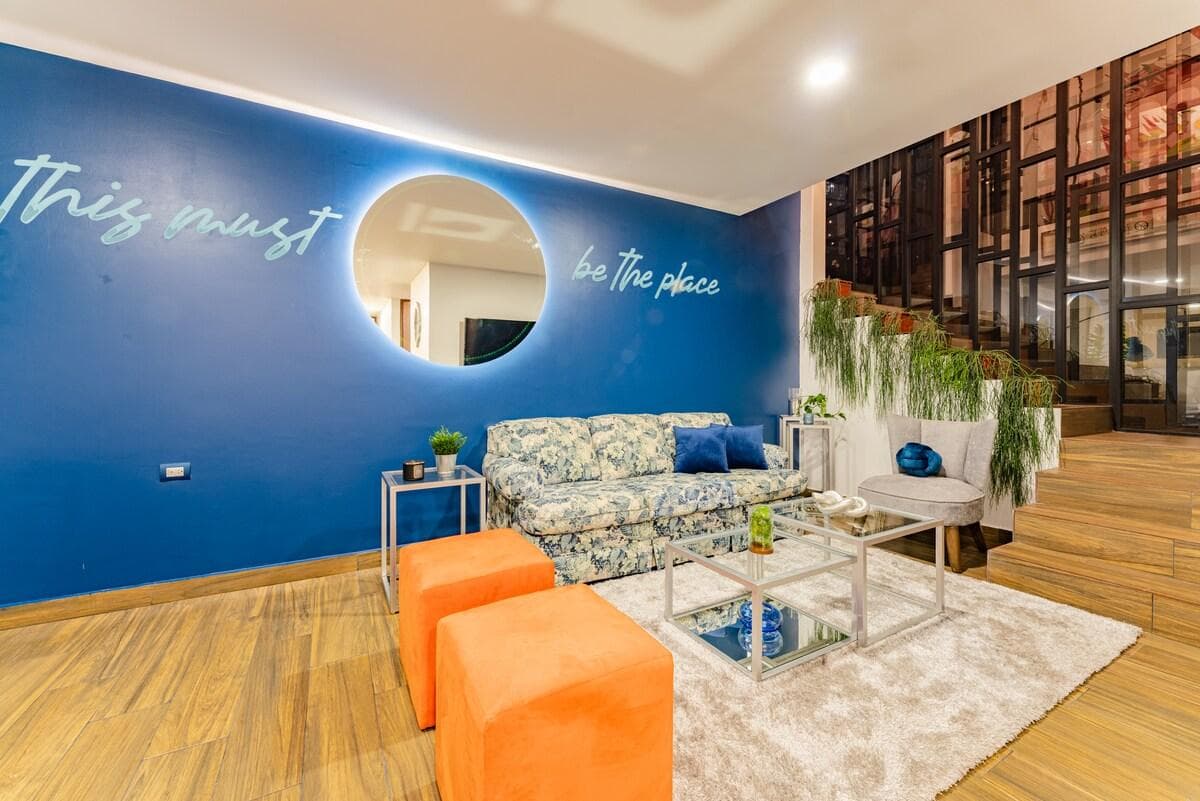 "This must be the place" lo que veras al entrar, uno de los detalles favoritos que te harán reafirmar que llegaste al lugar que buscabas, iluminación moderna, muebles cómodos y plantas naturales convierten este espacio en una sala super acogedora.