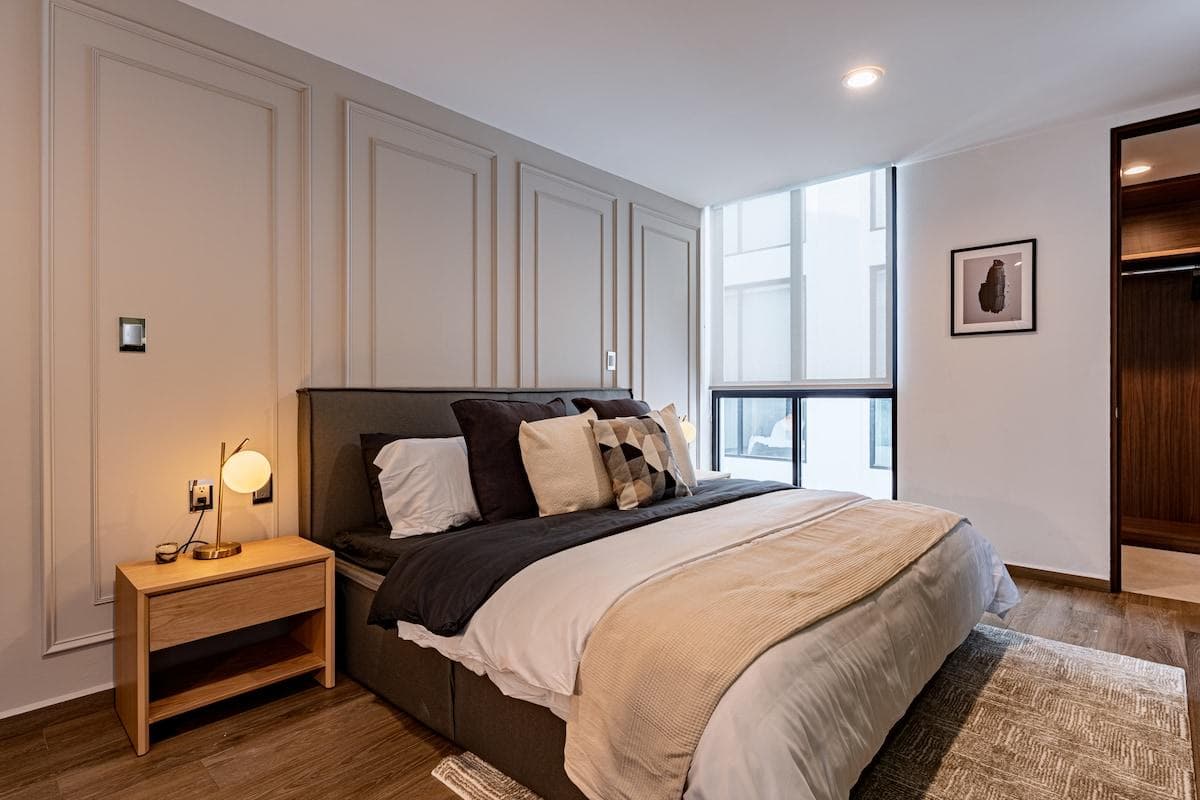 Main bedroom with large windows and soft neutral tones for a calming feel