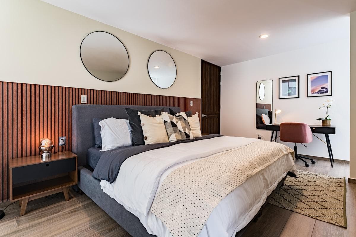 Spacious master bedroom with chic decor, cozy linens, and ambient lighting.