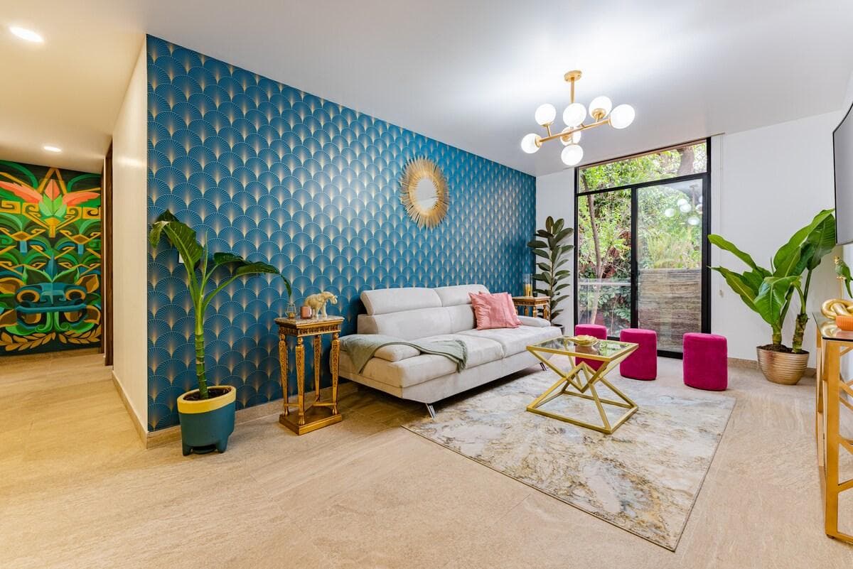 El Estilo Art Déco surgió en los años 20 y 30. Marcado por la elegancia y la sofisticación. En esta fotografía se aprecia la sala, el espacio principal de este alojamiento y el mural intervenido al fondo del pasillo por un talentoso artista mexicano.
