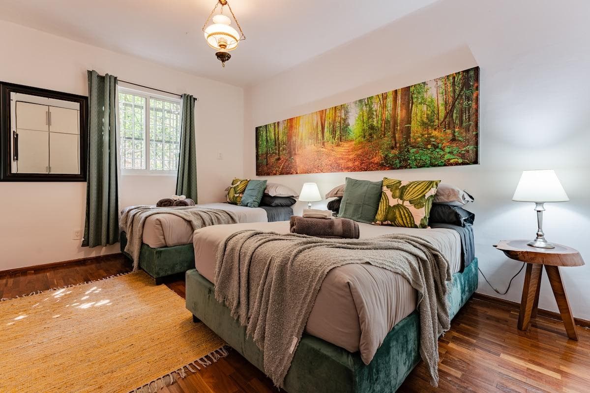 Bedroom with cozy decor, inviting bedding, and large windows.
